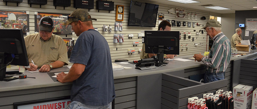 Customers at parts counter interacting with Parts Sales Representatives